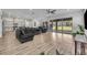 Open-concept living area with wood floors, a sleek kitchen, and access to outdoor patio through sliding glass doors at 17537 Sailfin Dr, Orlando, FL 32820