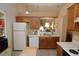Efficient kitchen features wood cabinets, white appliances, and a pass-through to the living area at 1754 Torrington Cir, Longwood, FL 32750