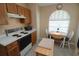 Kitchen showcasing oak cabinets, a white range, and a cozy breakfast nook with a window at 1754 Torrington Cir, Longwood, FL 32750