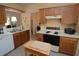 Kitchen shows wood cabinets, neutral countertops, and essential appliances for functional meal preparation at 1754 Torrington Cir, Longwood, FL 32750