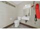 Simple bathroom featuring a toilet, sink, mirror, and essential amenities at 181 W Minnehaha Ave, Clermont, FL 34711