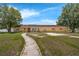 Charming one-story home with a stone walkway leading to the front door, showcasing a well-maintained lawn at 181 W Minnehaha Ave, Clermont, FL 34711