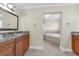 Well-lit main bathroom with wooden cabinetry, granite counters, and soaking tub at 181 W Minnehaha Ave, Clermont, FL 34711