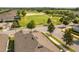 Neighborhood aerial view featuring rooftops and manicured lawns, adjacent to the golf course and mature landscaping at 2156 Antilles Club Dr, Kissimmee, FL 34747