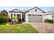 Charming single-story home featuring a manicured lawn, stone-paved driveway, and an attached two-car garage at 2156 Antilles Club Dr, Kissimmee, FL 34747