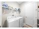 Functional laundry room equipped with washer, dryer, and ample shelving at 2156 Antilles Club Dr, Kissimmee, FL 34747