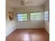 Living room with wood flooring, several windows, and a view of an adjoining kitchen at 2233 N Normandy Blvd, Deltona, FL 32725