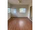 Cozy living room featuring wood-look flooring, large windows, and a modern ceiling fan at 2233 N Normandy Blvd, Deltona, FL 32725