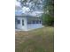 Enclosed sunroom with multiple windows and a door to the backyard, surrounded by lush greenery at 2233 N Normandy Blvd, Deltona, FL 32725