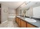 Bathroom featuring double sinks with a large mirror and a tiled tub at 2354 Barons Ct, Tavares, FL 32778