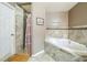Bathroom showcasing a tiled shower, garden tub, and neutral paint at 2354 Barons Ct, Tavares, FL 32778