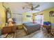 Bright bedroom featuring laminate floors, a ceiling fan, and playful décor at 2354 Barons Ct, Tavares, FL 32778