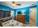 Bedroom boasting bright blue walls, ceiling fan, and neutral flooring at 2354 Barons Ct, Tavares, FL 32778