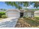 Charming single-story home with a well-manicured lawn, neutral paint, and an attached two-car garage at 2354 Barons Ct, Tavares, FL 32778