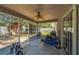 Covered and screened porch with ceiling fan, string lights, and views of the backyard playground and fence at 2354 Barons Ct, Tavares, FL 32778