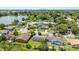 Aerial view of a residential neighborhood with tree-lined streets, green lawns and a lake in the distance at 245 Amador Cir, Orlando, FL 32810