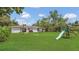 Spacious backyard featuring lush green grass, a swing set, and mature trees for shade at 250 Hickory Ave, Orange City, FL 32763