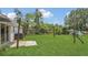 Spacious backyard featuring lush green grass, a swing set, and mature trees for shade at 250 Hickory Ave, Orange City, FL 32763