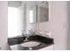 This bathroom features a dark countertop, a mirror, and a shower at 2536 Woodgate Blvd # 202, Orlando, FL 32822