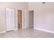 Neutral bedroom featuring tiled floors, bi-fold closet door, and en-suite bathroom at 2536 Woodgate Blvd # 202, Orlando, FL 32822