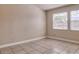 This bedroom boasts natural light and tiled floors at 2536 Woodgate Blvd # 202, Orlando, FL 32822