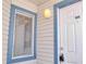 Close-up of the front door with window showing the exterior siding of the unit at 2536 Woodgate Blvd # 202, Orlando, FL 32822