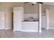 Open kitchen with white cabinetry, breakfast bar, and appliances next to the living room at 2536 Woodgate Blvd # 202, Orlando, FL 32822