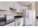 Kitchen with white cabinets, granite countertops, and appliances including a dishwasher and range at 2536 Woodgate Blvd # 202, Orlando, FL 32822