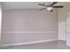 Neutral living room with tiled floor, ceiling fan and adjacent white door at 2536 Woodgate Blvd # 202, Orlando, FL 32822