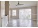 Bright living room with tile floors, ceiling fan, and sliding glass doors leading to a patio at 2536 Woodgate Blvd # 202, Orlando, FL 32822