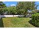 Green backyard showcasing a well-maintained lawn and a white fence providing privacy and security for the home at 2762 Pepper Ln, Orlando, FL 32812