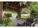 Charming backyard patio featuring brick pavers, string lights, cozy seating, lush plants and a lush grassy area at 2762 Pepper Ln, Orlando, FL 32812