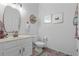 Cozy powder room with a stylish mirror, neutral walls and floor, and decorative accents at 2762 Pepper Ln, Orlando, FL 32812