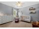 Cozy Bedroom features a crib, dresser, and plenty of natural light at 2762 Pepper Ln, Orlando, FL 32812