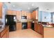 Well-lit kitchen featuring wooden cabinets, granite countertops, and stainless steel appliances at 2762 Pepper Ln, Orlando, FL 32812