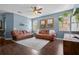Comfortable living room features hardwood floors, a ceiling fan, leather sofas, and a neutral rug at 2762 Pepper Ln, Orlando, FL 32812