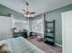 Inviting bedroom featuring a comfortable bed, large windows, ceiling fan, and a stylish black bookcase at 293 Drosdick Dr, Casselberry, FL 32707