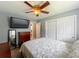 Bedroom featuring large television, wood dresser, ceiling fan, and door to ensuite bathroom at 293 Drosdick Dr, Casselberry, FL 32707