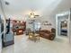 Open-concept living room features ceramic tile, an adjacent kitchen, and cozy furniture at 293 Drosdick Dr, Casselberry, FL 32707