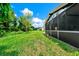 A view of screened lanai, and large grassy backyard surrounded by mature trees at 309 Black Springs Ln, Winter Garden, FL 34787