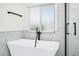 An opulent soaking tub sits beneath a window and next to a seamless glass shower at 309 Black Springs Ln, Winter Garden, FL 34787