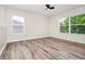 Light and airy bedroom with wood-look floors, two windows, and neutral walls at 309 Black Springs Ln, Winter Garden, FL 34787