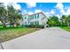 Charming two-story home featuring teal shutters, a well-manicured lawn, and an expansive driveway at 309 Black Springs Ln, Winter Garden, FL 34787