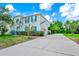 Charming two-story home featuring teal shutters, a well-manicured lawn, and an expansive driveway at 309 Black Springs Ln, Winter Garden, FL 34787
