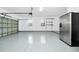 A clean garage with epoxy flooring and a refrigerator at 309 Black Springs Ln, Winter Garden, FL 34787