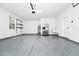 A spacious, clean garage featuring epoxy floors, shelves, and a refrigerator at 309 Black Springs Ln, Winter Garden, FL 34787