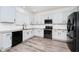 Bright kitchen featuring white cabinets, granite countertops, stainless steel appliances, and wood-look flooring at 309 Black Springs Ln, Winter Garden, FL 34787