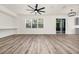 Spacious living area featuring wood-look floors and neutral walls, seamlessly connecting to the kitchen at 309 Black Springs Ln, Winter Garden, FL 34787