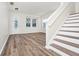 Bright living room featuring wood-look floors, neutral walls, windows, and staircase to the right at 309 Black Springs Ln, Winter Garden, FL 34787
