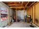 Spacious garage interior featuring unfinished walls, exposed wood beams, and access to a roll-up garage door at 315 Panama Cir, Winter Springs, FL 32708